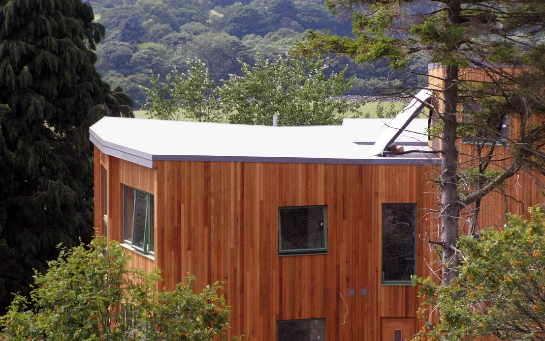 Timber clad property with a new single-ply roof extension and integral gutter, Dalbeattie